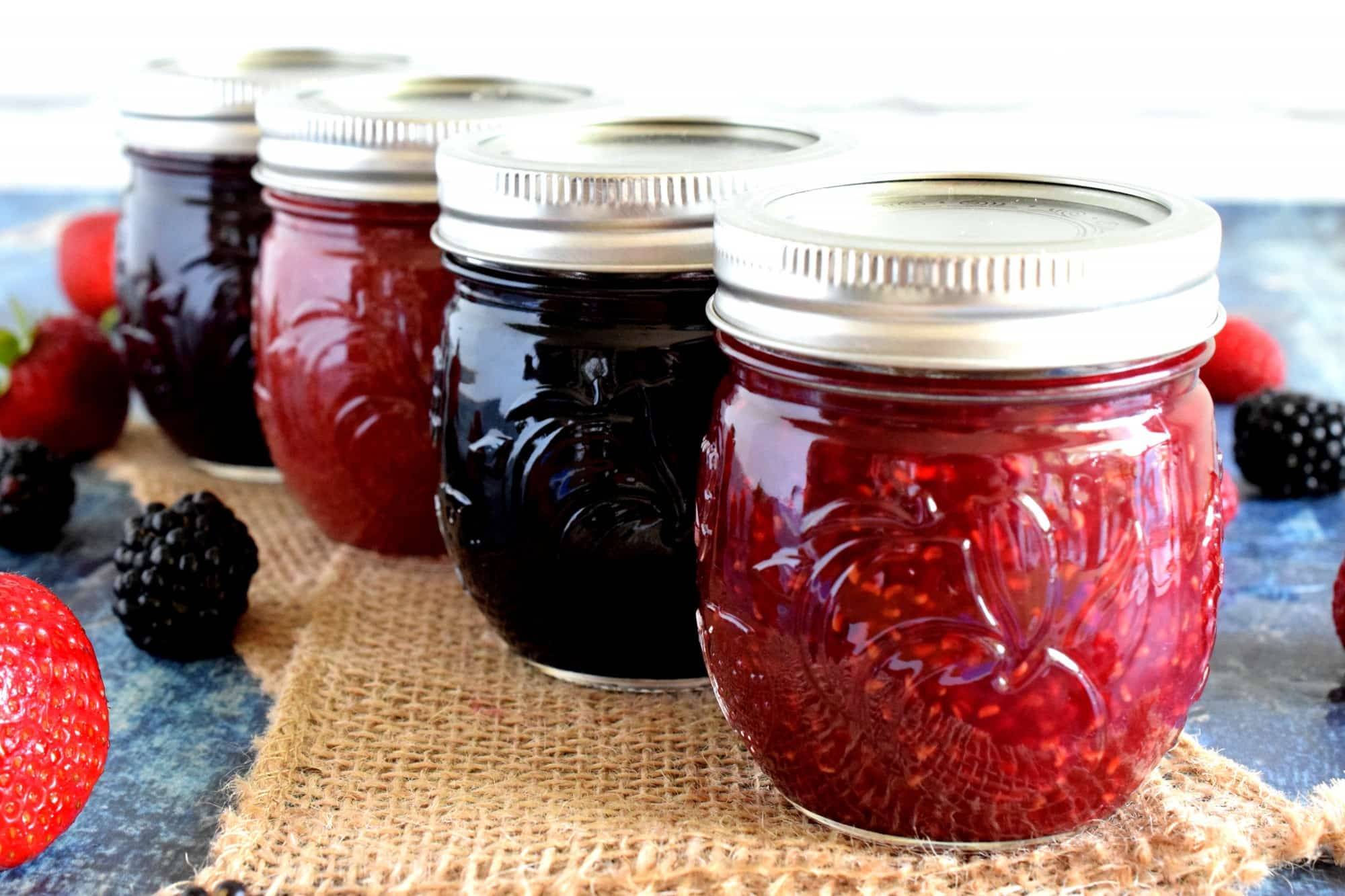 Potten huisgemaakte jam op een houten plank als beeld voor ambachtelijke confiture