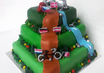 Fietsvakantie taart met bergachtig tafereel en vlaggetjes van Europa