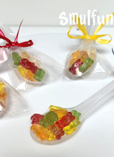 Lepel gevuld met fruitige beren snoepjes als traktatie