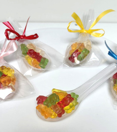 Lepel gevuld met fruitige beren snoepjes als traktatie